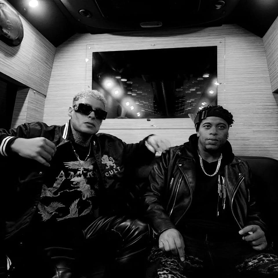 Kaleb Simmonds and Andru Winter sitting together in a tour bus, black and white photo